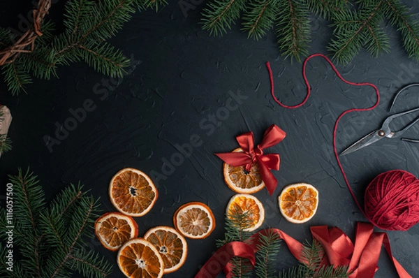 Fototapeta Christmas decoration and wrappung gifts on black background flat lay top view eco sustainable composition with pine branches and dried oranges copy space cute ribbons