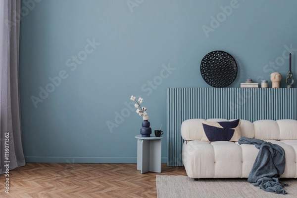 Obraz Modern living room in serene blue tones with a cozy white sofa, abstract decor, and a minimalist side table arrangement.