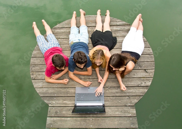 Obraz Gruppe Jugendliche mit Notebook / Laptop draußen in der Natur