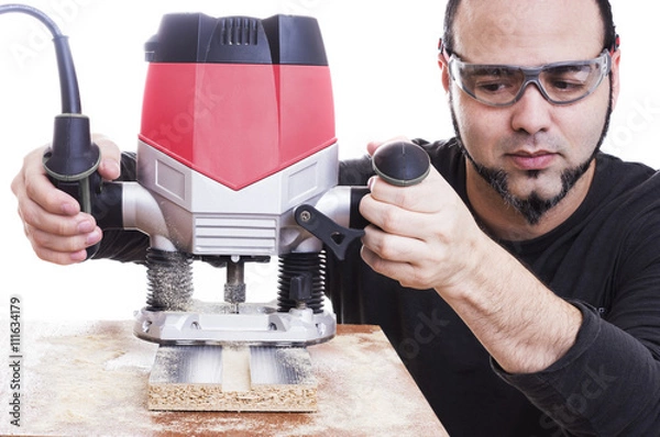 Fototapeta Man using a Plunge router, making a groove on wood