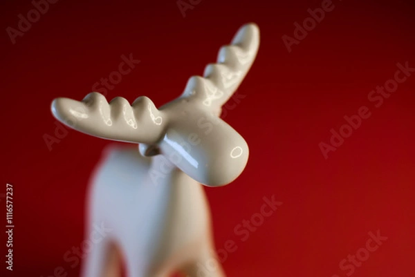 Obraz A stylized White Moose Figurine on a vibrant red background, perfect for display