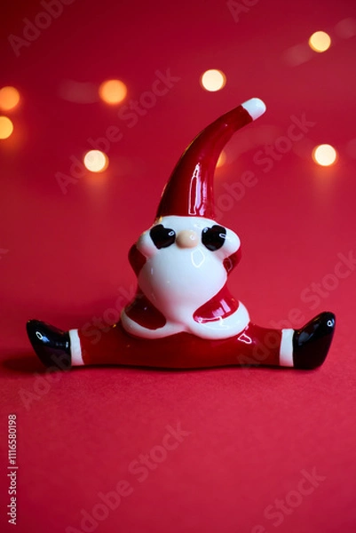 Obraz A festive Santa figurine is beautifully set against a red background with shimmering bokeh