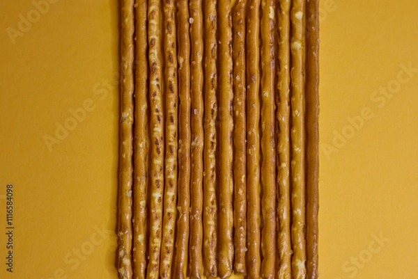 Obraz Artfully arranged pretzel sticks are presented beautifully against a vibrant yellow background