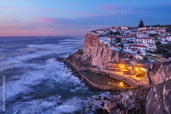 Fototapeta Scenic view of the seaside Azenhas do Mar fishing village on cliff on Atlantic ocean coast, Portugal in evening twilight dusk
