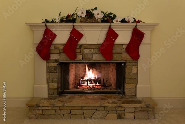 Fototapeta Four red Christmas stockings on a beautiful stone fireplace in a residence.