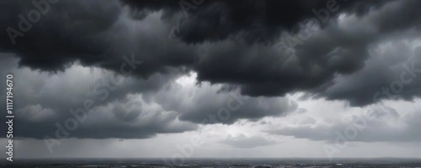 Fototapeta Grey rain clouds suspended in a dull grey sky with low hanging clouds and heavy precipitation , gloomy atmosphere, low hanging clouds