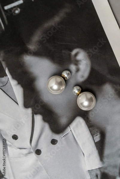 Fototapeta Simple earrings with pearls on the black and white magazine