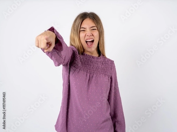 Fototapeta Beautiful teenager girl wearing purple T-shirt pointing displeased and frustrated to the camera, angry and furious ready to fight with you.