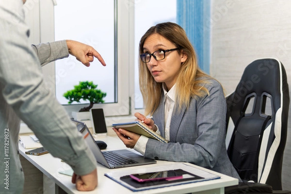 Fototapeta businesswomen suit with boss pointing finger yelling reprove argument sitting on table document report laptop at workplace. the boss gives orders to the subordinate.. Scene tense and confrontational