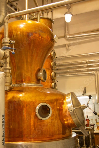 Obraz Distillate production process in copper distillation unit. Cpper vacuum still for distillation performed under reduced pressure for gin production.