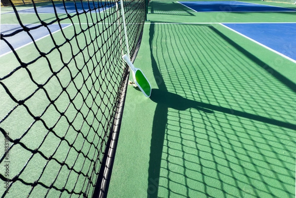Fototapeta Low-angle view of outdoor pickleball court with net and paddle