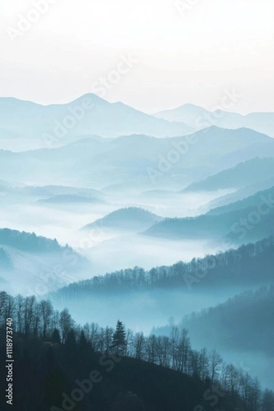 Fototapeta Serene mountain landscape shrouded in mist and soft blue hues.