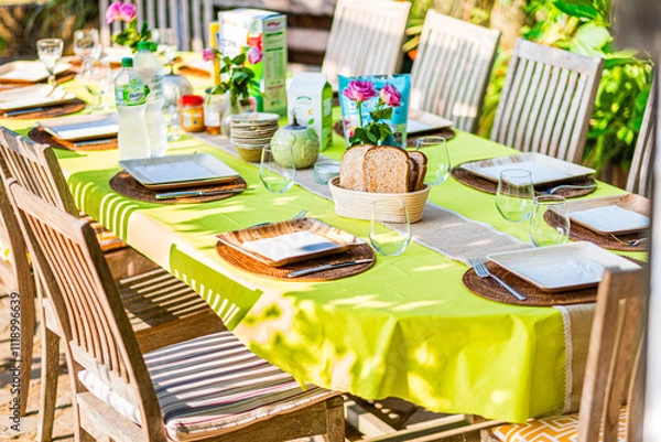 Obraz Outdoor Table Set For a Vibrant Brunch Gathering With Colorful Tablecloth and Fresh Flowers
