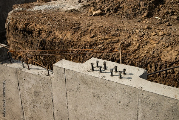 Obraz Concrete foundation with steel anchor bolts ready   for next phase of construction of new commercial building.



