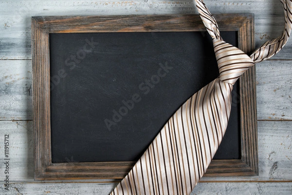 Obraz Fathers day concept, empty framed chalkboard and tie on wooden background
