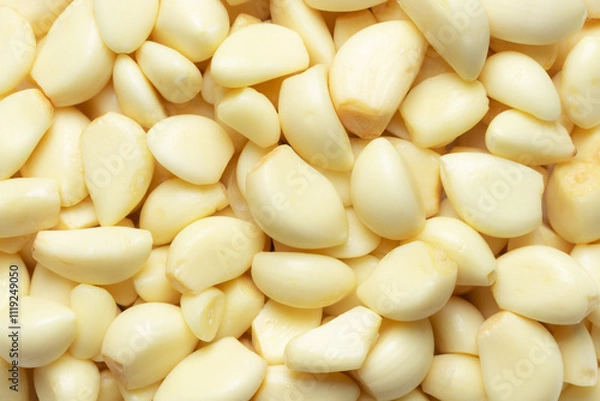 Fototapeta Heap of peeled garlic cloves for background. Top view