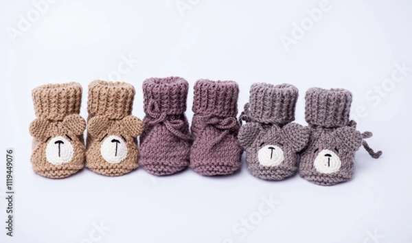 Obraz Handmade knitted baby booties on light background. Isolated