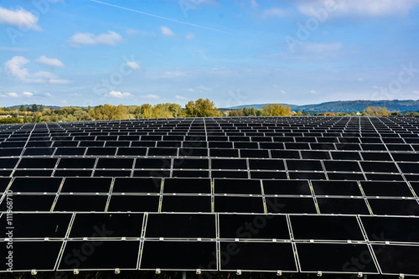 Obraz A field of solar cell placing with the scenery on trees and mountain.