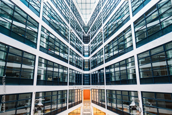Obraz Modern Office Building Interior With Symmetrical Glass Windows and Bright Architecture Featuring a Staircase at the Core, Creating a Futuristic Perspective in a Contemporary Urban Work Environment