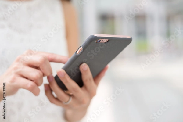 Fototapeta Woman sending message on smart phone