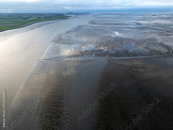 Fototapeta Aerial view of a tidal channel and mudflats near Termunterzijl, Groningen, The Netherlands