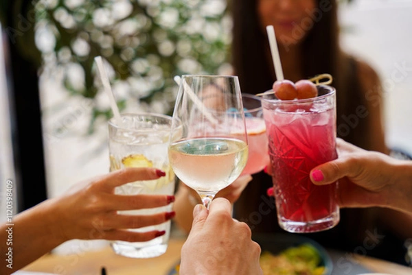 Obraz Friends toasting with cocktails and wine at a bistro