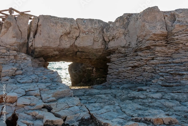 Obraz Unique natural rock formation with distinctive arch carved out by elements in Kamenjak National Park. Frames a view of calm Adriatic Mediterranean Sea in Premantura, Istria peninsula, Croatia, Europe