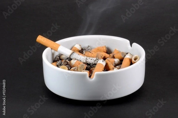 Obraz White ceramic ashtray full of smokes cigarettes. Selective focus.