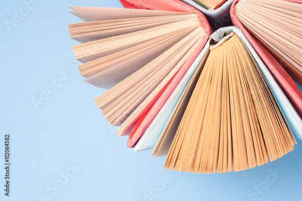 Fototapeta Top view of bright colorful hardback books in a circle. Open book, fanned pages.   Education essential for self improvement, gaining knowledge and success in our careers, business and personal lives.