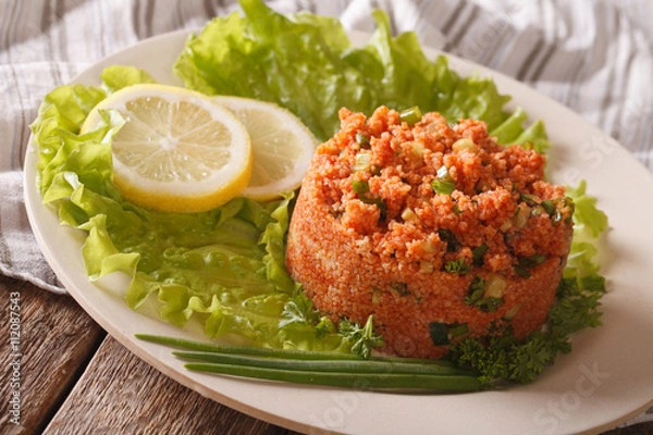 Fototapeta Turkish appetizer spicy kısır of bulgur with herbs on the table. Horizontal
