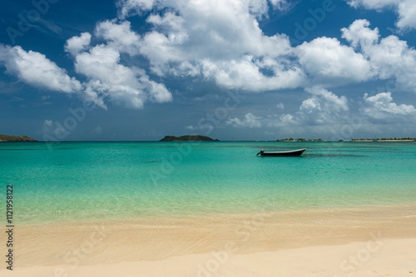 Fototapeta View across the tranquil turquoise lagoon at Carriacou's Paradise Beach to Mabouya Island and Sandy Island on the horizon.