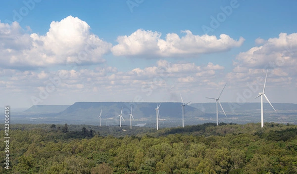 Obraz A windmill power farm in the northeast of Thailand, featuring large wind turbines spinning in the open landscape. This image highlights renewable energy, clean power generation