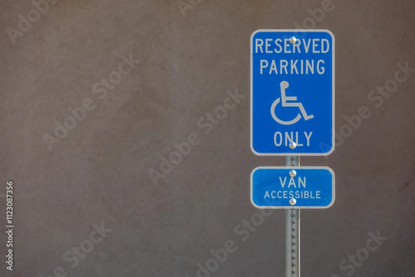 Fototapeta Sign "Reserved Parking Only; Van Accessible" in a Parking Lot with impressive Rock Formation in Background, plenty of Copy Space