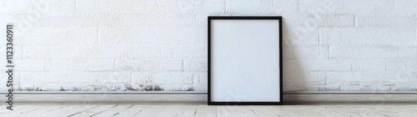 Fototapeta Minimalist Black Frame Display, a blank black horizontal frame resting on the floor against a simple wall, emphasizing clean lines and abundant empty space for creative use