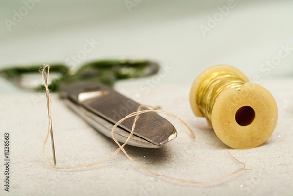 Obraz Scissors reel of thread, measuring tapes and natural fabric. Sewing textile or cloth. Work table a tailor.