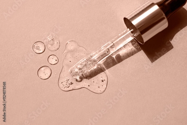 Fototapeta Serum drops and a pipette on a beige background. Top view. Color of the Year Mocha Mousse.
