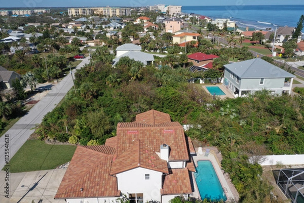 Obraz Aerial looking north over New Smyrna Beach, Florida neighborhoods, beachfront hotels and condos and the Atlantic Ocean.