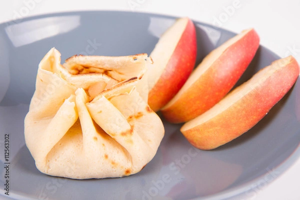 Fototapeta Pancake sack stuffed with braised apples decorated with apple slices