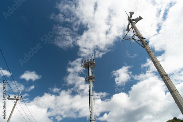 Fototapeta 送電線と携帯電話のアンテナと防災無線のスピーカーの柱