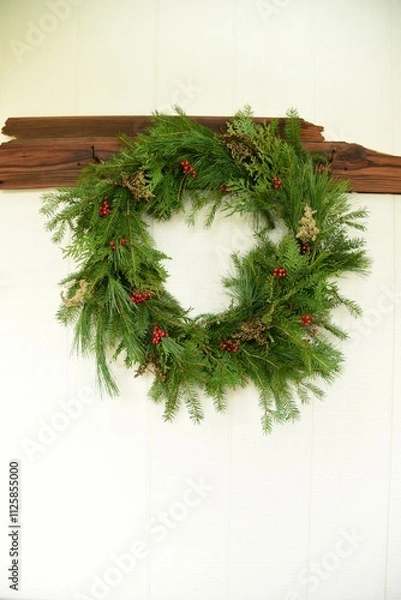 Obraz Natural Evergreen Wreath with red berries on White Wood Background