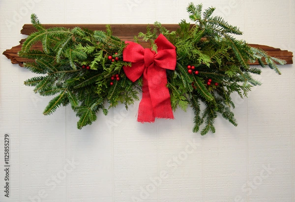 Obraz Natural Evergreen Swag Branches with Red bow on White Wood Background