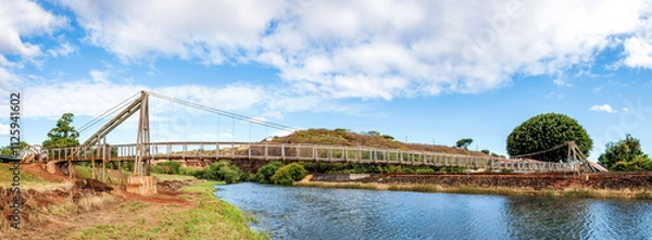 Fototapeta The historic Hanapepe Swinging Bridge, located on Kauai, Hawaii, was built in 1911. The pedestrian suspension bridge connected the town of Hanapepe with agricultural fields in the Hanapepe Valley.