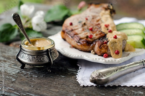 Fototapeta Pork steak, mustard in a jar on the table. Vintage style.