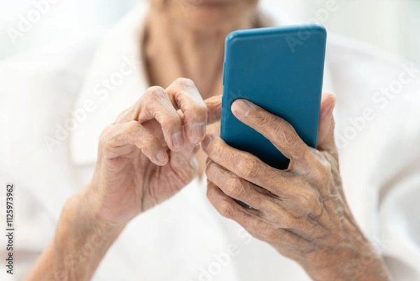 Obraz Closeup of hands,Asian senior woman using smartphone,old elderly holding mobile phone,concept of technology, financial deception,cybercrime,victim of scams,internet fraud,online scams, cyber threats