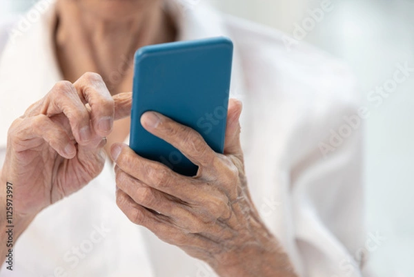Obraz Closeup of hands,Asian senior woman using smartphone,old elderly holding mobile phone,concept of technology, financial deception,cybercrime,victim of scams,internet fraud,online scams, cyber threats
