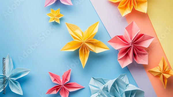 Fototapeta  a colorful arrangement of origami flowers on a pastel-colored background, creating a cheerful and artistic display The paper flowers are in shades of yellow, pink, and light blue