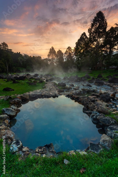 Fototapeta Hot springs over rock terrain with misty and morning sunrise rays and Natural Mineral Water of Chae Son National Park in Lampang Province, Thailand.