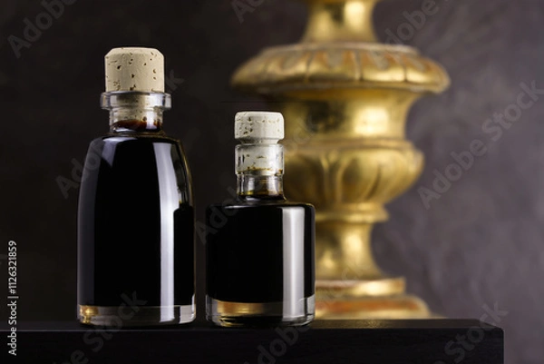 Fototapeta Due bottigliette di aceto balsamico, condimento tipico di Modena, isolate su fondo scuro, primo piano