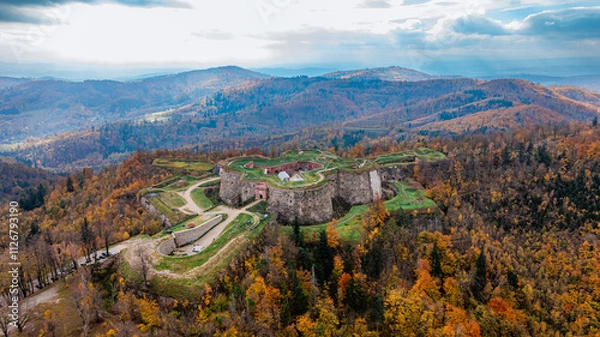 Fototapeta Twierdza Srebrna Góra jesienią, otoczona żywymi kolorami liści i zachwycającymi krajobrazami.