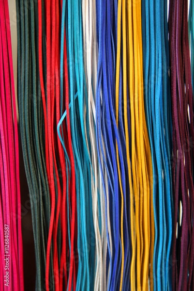 Fototapeta Thin, colorful leather strips arranged as a decorative background for braiding and crafting